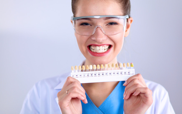 Attractive female dentist with tools , standing on gay background - Foto, Imagem