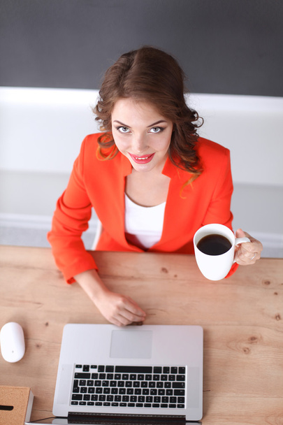 Houkutteleva nainen istuu toimistossa, työskentelee kannettavan tietokoneen kanssa - Valokuva, kuva