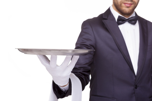 waiter holding an empty silver tray - Foto, afbeelding