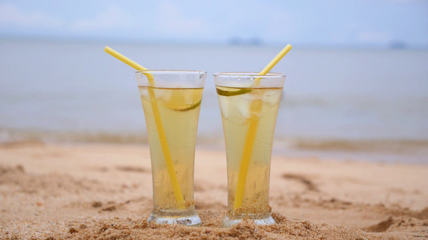 2 つのグラスのカップルと砂浜にジュースをさわやかな. - 映像、動画