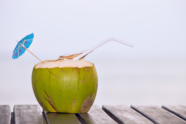 Coconut water drink served in coconut with drinking straw on the - Photo, Image