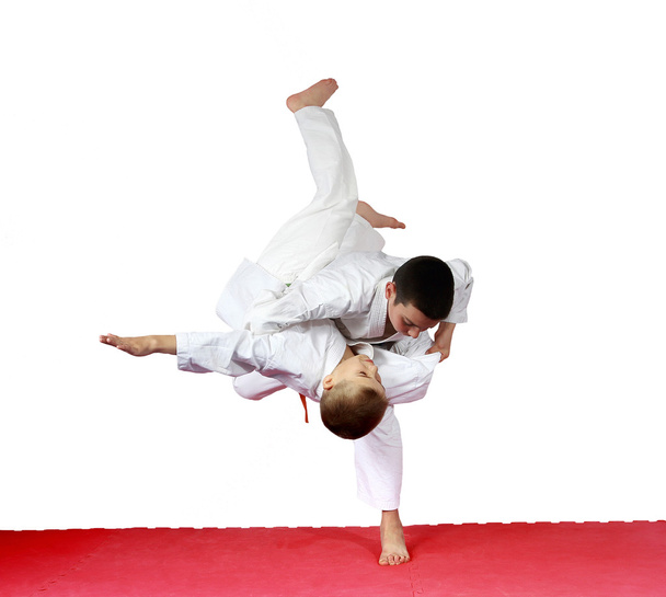 En una alfombra roja atletas están entrenando judo lanza
 - Foto, imagen