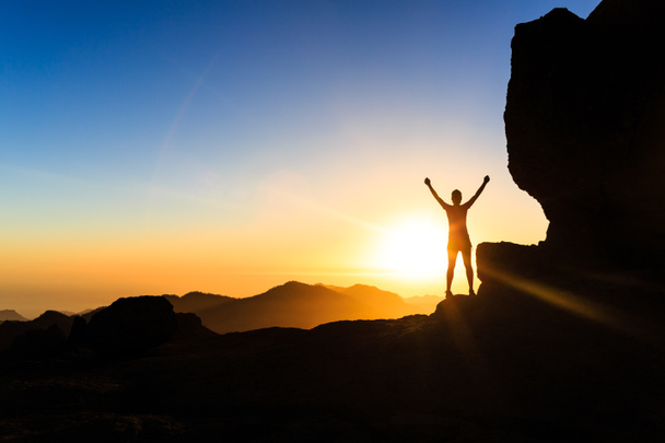 Vrouw klimmer succes silhouet in de bergen, de Oceaan en de zonsondergang - Foto, afbeelding