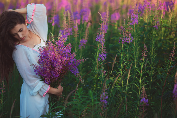 a woman with her eyes closed, posing in a field of lavender, hol - Foto, Imagen