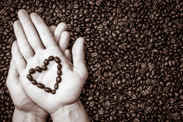 Кофе в зернах символ сердца на верхней части руки
 - Фото, изображение