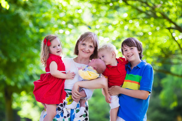 Porträt einer glücklichen Frau mit vier Kindern - Foto, Bild