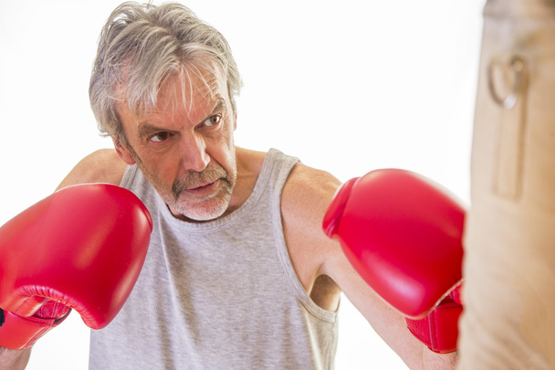 Senior man using a punching bag - Foto, Imagem