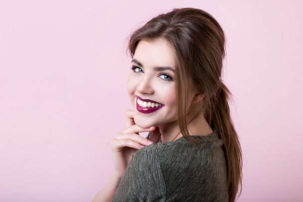 Portrait of attractive girl with red lips on a pink background. - Valokuva, kuva
