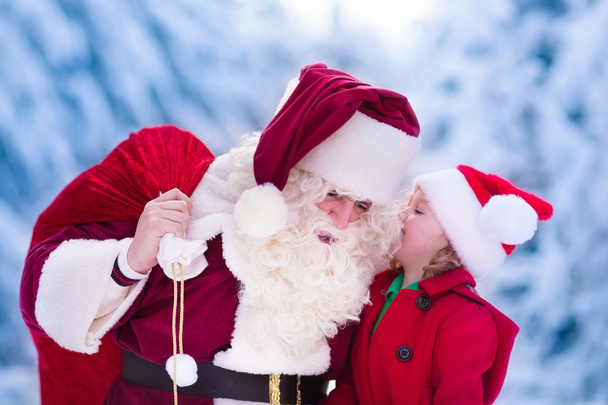 Noel Baba karlı parkta küçük kız konuşuyor - Fotoğraf, Görsel
