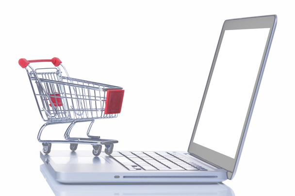 Shopping cart over a laptop computer - Foto, Bild