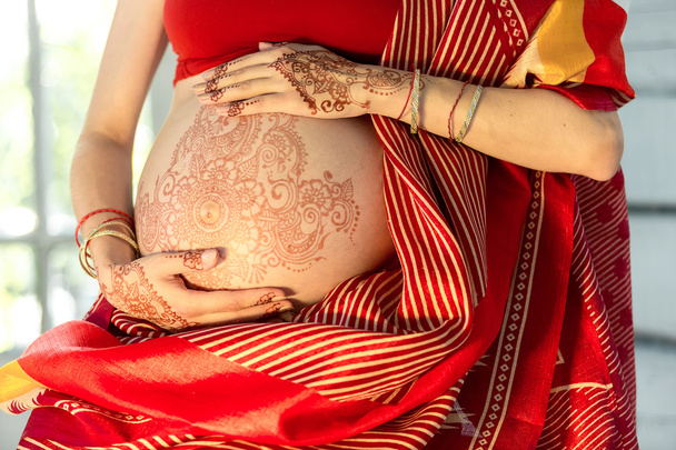 The pregnant woman belly with henna tattoo - Photo, image