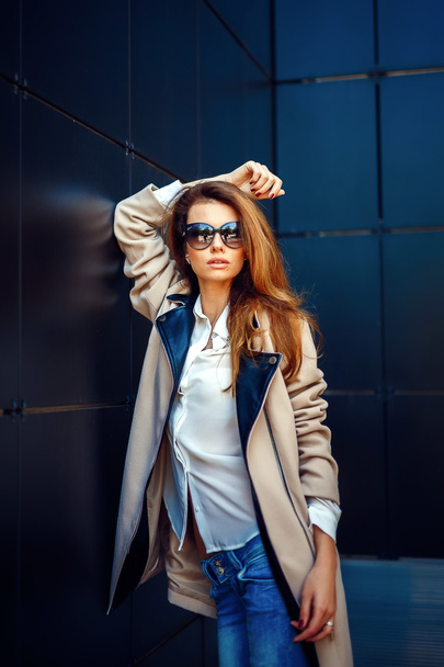 girl in a beige coat and blue jeans - Photo, Image