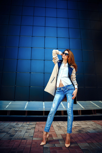 girl in a beige coat and blue jeans - Foto, Imagem