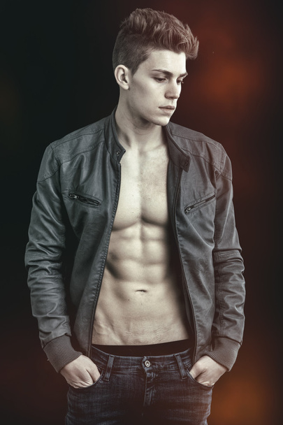 Handsome young man wearing leather jacket on naked torso - Foto, afbeelding