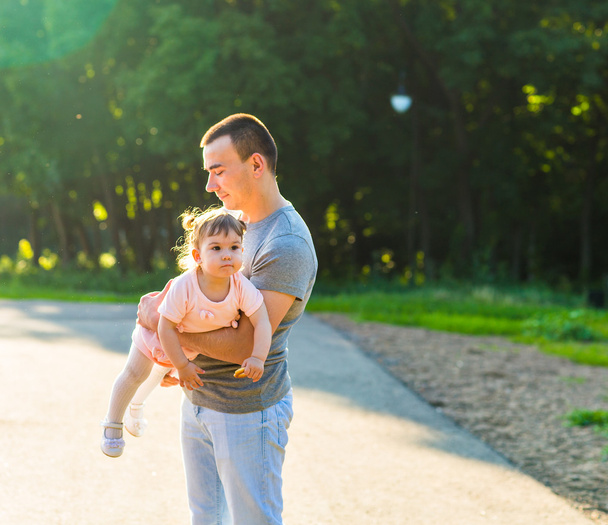 baby girl walking in a summer park with her father - Photo, Image