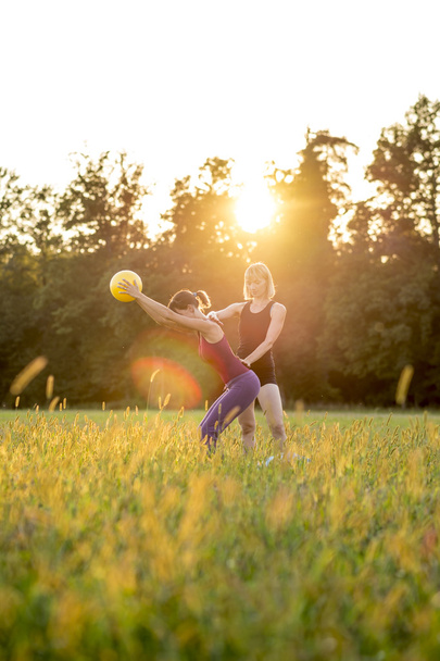 Two women working out in a green field - Foto, immagini