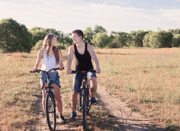 νεαρό ζευγάρι που έχοντας ένα ποδήλατο βόλτα στη φύση - Φωτογραφία, εικόνα