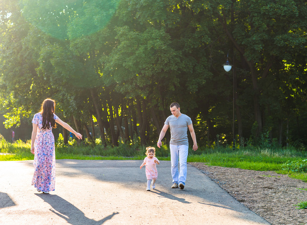 Ευτυχισμένη οικογένεια περπατά στο πάρκο. - Φωτογραφία, εικόνα