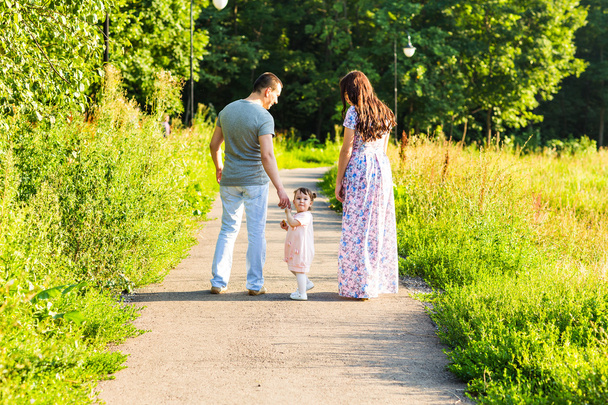 Happy Young Family Walking In The Park. - 写真・画像