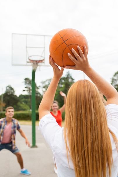 group of happy teenagers playing basketball - Foto, Bild