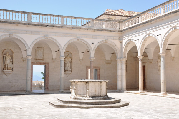 Подвір'ї монастиря бенедиктинців в Монте-Кассіно, Кам'яний фонтан і аркади - Фото, зображення