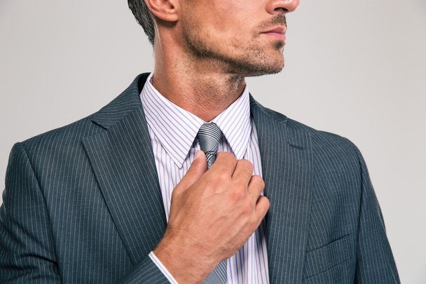 Businessman straightening his tie - 写真・画像