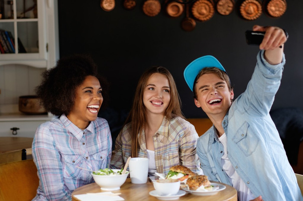 monirotuinen ystävät ottavat selfie kahvilassa
 - Valokuva, kuva