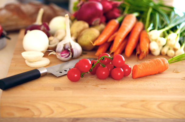 Свежие органические овощи на столе с ножом для приготовления пищи
 - Фото, изображение