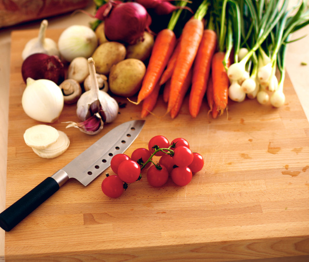 Legumes orgânicos frescos em uma mesa com uma faca para cozinhar
 - Foto, Imagem