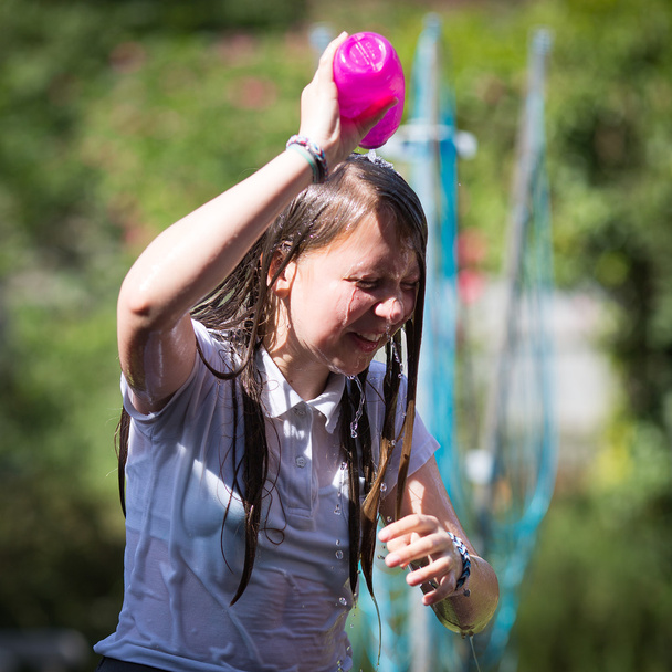 Adolescente chica se enfría por tirar agua sobre su cabeza
 - Foto, imagen