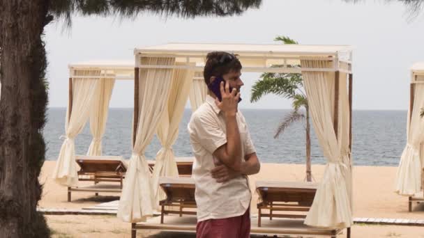 Парень говорит по телефону на пляже
 - Кадры, видео