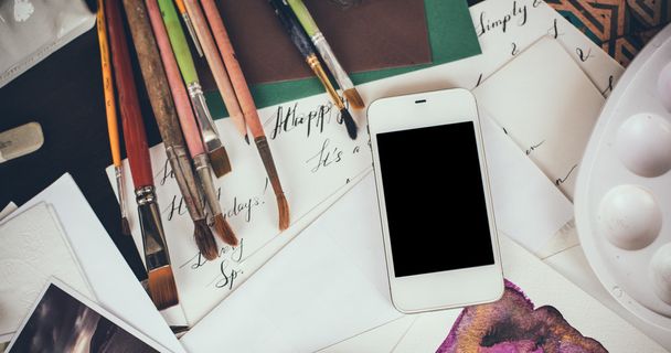 Smartphone on a table in the artist studio - Photo, Image