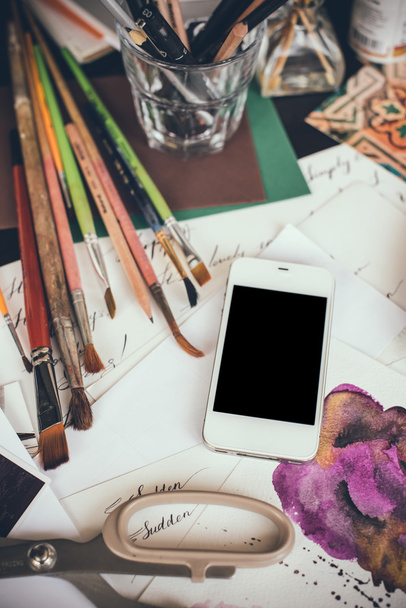 Smartphone en una mesa en el estudio del artista
 - Foto, imagen