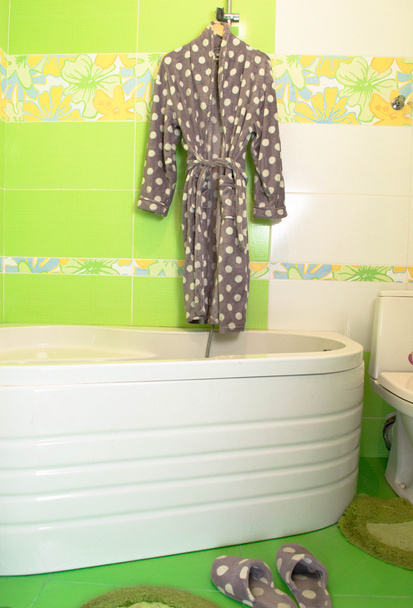 Cream bathrobe on hanger with Lime green mosaic tiles background - Photo, Image