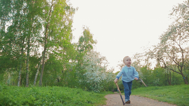 Boldog gyermek futás az úton, a parkban - Felvétel, videó