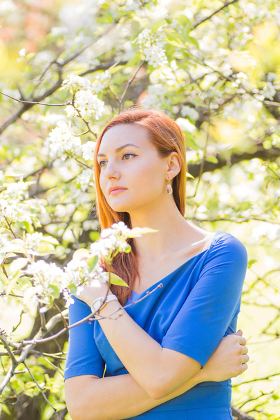 Piękna rudowłosa dziewczyna w niebieska sukienka wśród wiosną kW - Zdjęcie, obraz