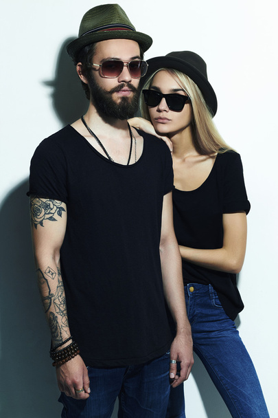 beautiful couple in hat together. Hipster boy and girl. Bearded young man and blonde in sunglasses - Foto, Bild