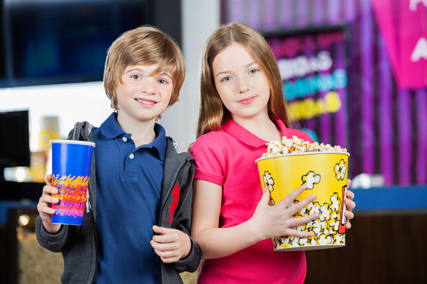 Cute Brother And Sister Holding Snacks At Cinema - Foto, Bild