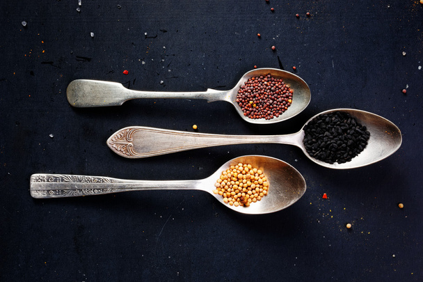 Spices on spoons on a black background - Photo, Image