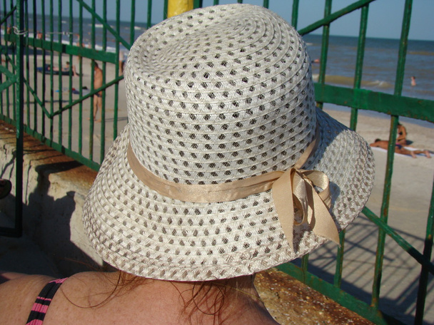 hattu ranta sulkeutuu auringolta, erilaisia rantahattuja peittää pään auringonvalolta
. - Valokuva, kuva