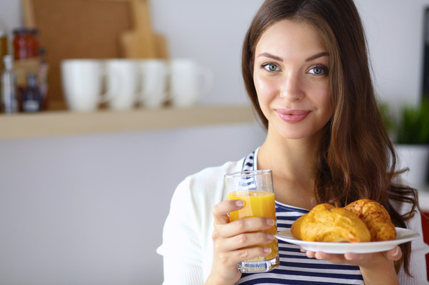 Young woman with glass of juice and cakes - Foto, afbeelding