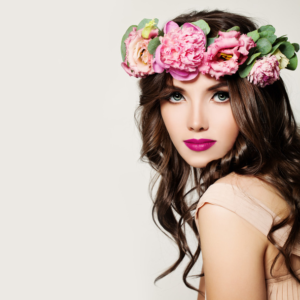 Μόδα γυναίκα. Κορίτσι με μακιγιάζ, σγουρά μαλλιά και ροζ λουλούδια - Φωτογραφία, εικόνα
