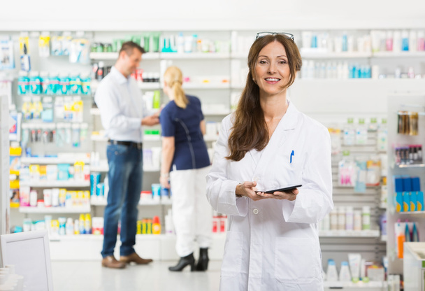 Smiling Female Chemist Holding Digital Tablet At Pharmacy - Foto, Imagen