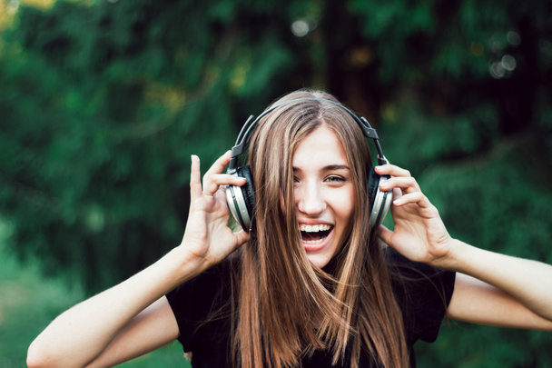 mooi meisje luisteren naar muziek op hoofdtelefoon . - Foto, afbeelding