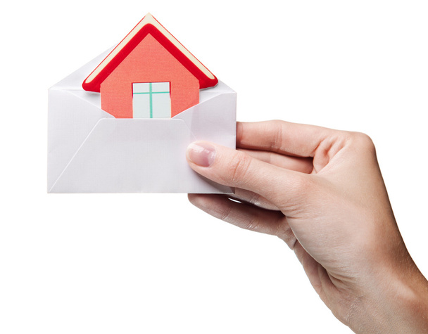 Рук женщины, держа конверт с признаком изоли дом - Фото, изображение