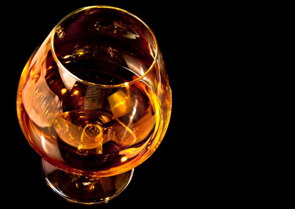 snifter of brandy in elegant typical cognac glass on black background - Photo, Image