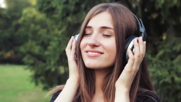 piękna, młoda dziewczyna, słuchanie muzyki na słuchawkach. - Materiał filmowy, wideo