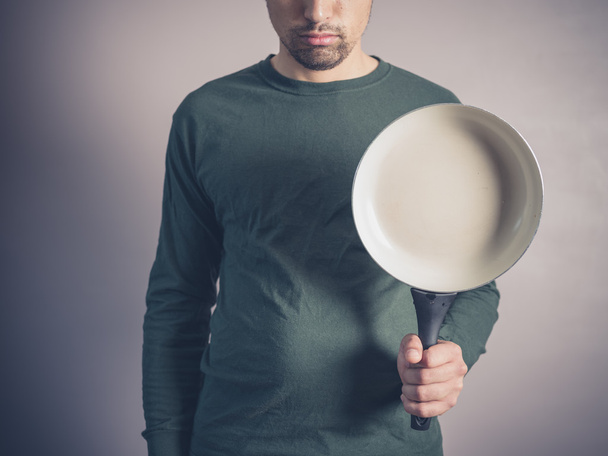 Young man with frying pan - 写真・画像