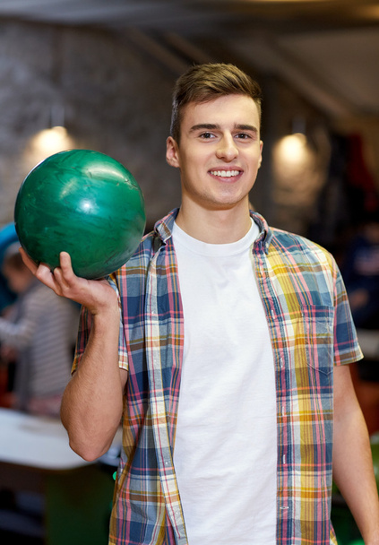 happy young man holding ball in bowling club - Фото, зображення