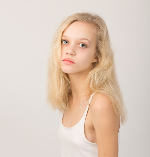 schöne ernsthafte blonde Teenager-Mädchen in weißem Top - Foto, Bild